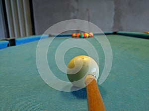 A close up of player take a shot of billiard ball.