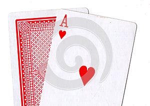 Close up of playing cards with the ace of hearts revealed.