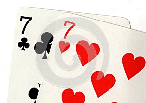 Close up of playing cards showing a pair of sevens.