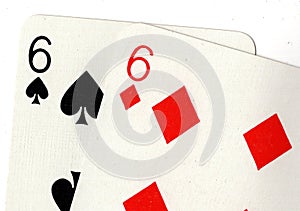 Close up of playing cards showing a pair of sixes.