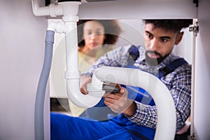 Close-up Of A Plumber Fixing Sink Pipe