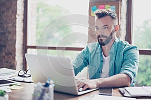 Close up of ponder freelance worker, wearing casual smart, concentrated, focused, serious, sitting at the work place, looking in