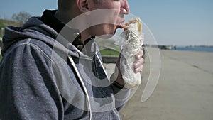 Close-up poor disabled eats doner kebab, portrait lonesome male