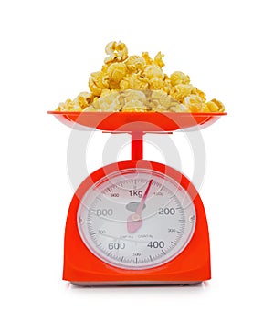 popcorn on red weigh scales isolated on white background