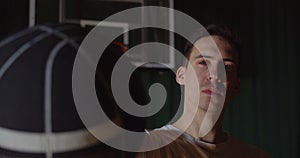 Close-up popular caucasian basketball player portrait playing with a basket ball on a background serious confident look