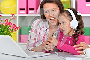 Porait of mother and daughter singing karaoke photo