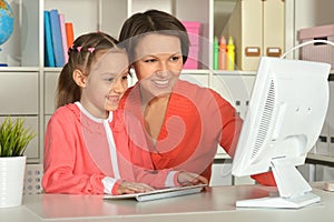 Close up porait of mother and daughter using laptop