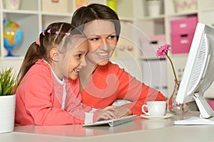 Close up porait of mother and daughter using laptop