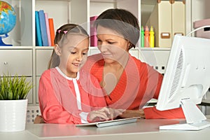 Close up porait of mother and daughter using laptop photo