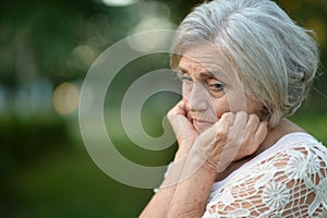 Porait of sad senior woman in park photo