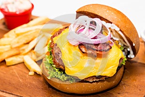 Close up on Pork burger with cheese, vegetable and served with fries