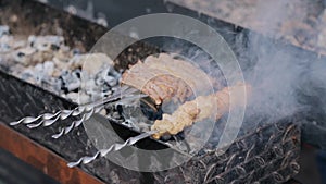 Close up of pork and chicken grilling on barbecue