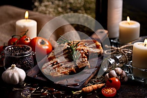 Close up pork chops steak with black pepper sauce placing on vintage wooden plate together with many ingredient