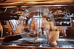 Close-up of a portafilter and cup with cappuccino next to a coffee machine in the restaurant of a coffee shop