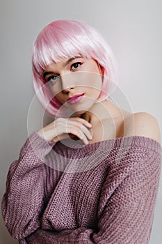 Close-up portrait of adorable caucasian female model wears elegant colorful peruke. Stunning lady with light-pink hair