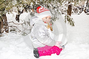 Close up portrait of adorable happy little girl grinning happily at the camera on a sunny winter`s day