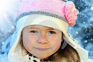 Close-up portrait of adorable smiling child girl wearing pink kn