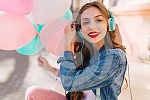 Close-up portrait of adorable smiling girl wearing denim jacket having fun at the birthday party. Stylish young woman