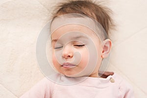Close-up portrait of adorable toddler baby girl sleeping in the bed.