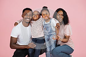 Close up portrait of african american man, woman and two girls sitting on the floor