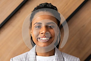 close-up portrait of an african american woman against a wall in an office with a big smile on her face