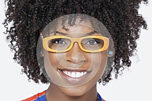 Close-up portrait of an African American woman wearing glasses over gray background