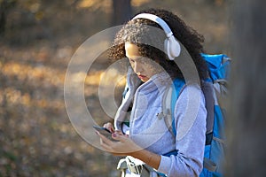 Close-up portrait of an african american woman, who lost in forest. Lost in forest and using GPS app in mobile phone