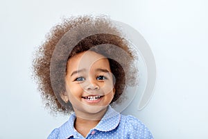 Close-up portrait of african child girl laughing, smiling, looking at camera