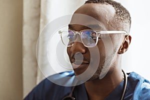 Close-up portrait of african young doctor, therapeutic or medical advisor at work, idoors . Concept of healthcare, care