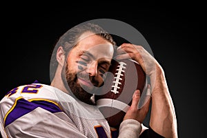 Close up portrait of American Football Player who gently holds the ball