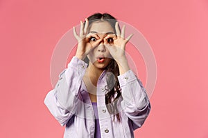 Close-up portrait of amused, speechless and impressed asian young girl seeing something curious and amazing, make