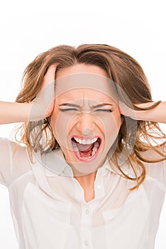 Close up portrait of angry businesswoman screaming and holding head