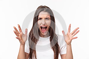 Close-up portrait of angry, pissed-off aggressive woman screaming at person, shouting and shaking hands from anger and