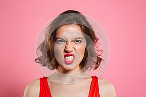 Close-up portrait of angry young woman with red lips looking at