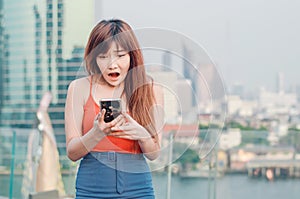 Close up portrait anxious young girl looking at phone seeing bad news or photos with disgusting emotion on her face over outside