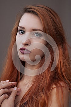 Close-up portrait of arrogant beautiful slim girl with long red hair