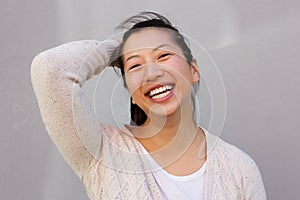 Close up portrait of asian woman smiling with hand in hair