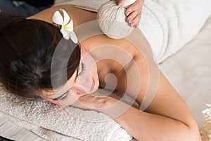 Close up portrait of attractive Asia woman having ayurvedic pinda mas