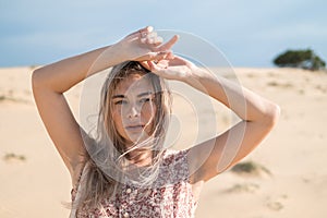 Close-up portrait of attractive blond caucasian young woman desert.