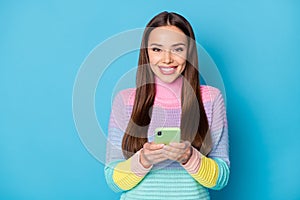 Close-up portrait of attractive cheerful girl using gadget browsing media wi-fi service isolated over bright blue color