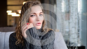 Close up portrait of attractive female international student during break in coffee shop waiting for classmates meeting