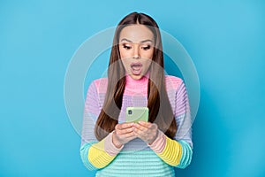 Close-up portrait of attractive focused amazed girl using gadget browsing fake news isolated on bright blue color