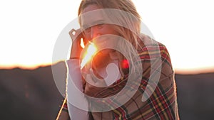 Close up Portrait of attractive girl young women traveleÐº in mountain in plaid in sunshine flares sunset. Dressed in