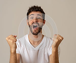 Close up portrait of attractive man surprised celebrating victory goal wining team or lottery