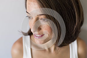 Close up portrait of an Attractive pregnant woman sitting in bed and holding her belly. Last months of pregnancy