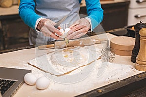 Close-up portrait of attractive senior aged woman is cooking on kitchen. Grandmother making tasty baking