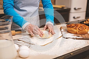 Close-up portrait of attractive smiling happy senior aged woman is cooking on kitchen. Grandmother making tasty baking