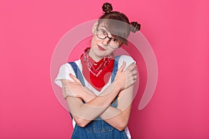 Close up portrait of attractive woman wearingdenim overalls, white casual t shirt, red bandana over neck, posing  over