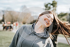 Close up portrait of attractive 40 years old woman enjoying life playing with her hair and smiling