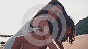 Close up portrait of a attractive young and energetic couple having fun on the beach. Woman piggyback riding a man and